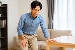 足の痺れを気にしている男性